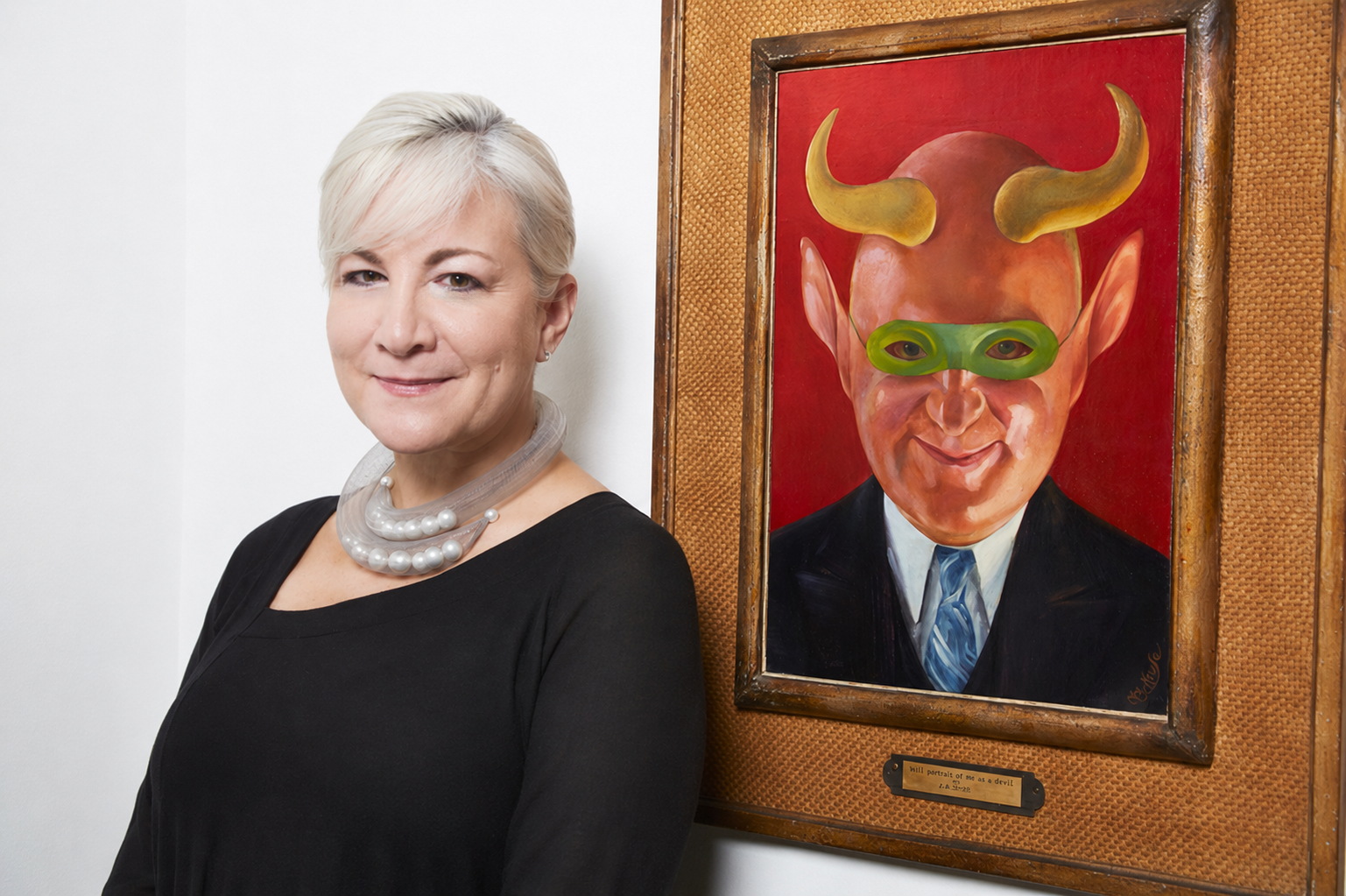 Sharon Aponte standing beside a framed painting